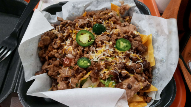 A plate full of Nacho's and its fixings