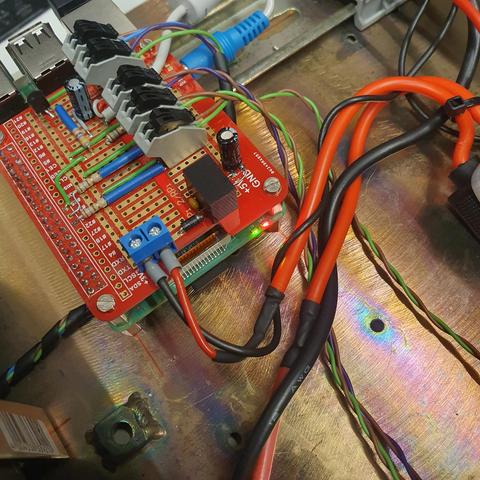 Custom Raspberry pi header with a red and green status LED, both on,  and a couple of wires inside the transmitter