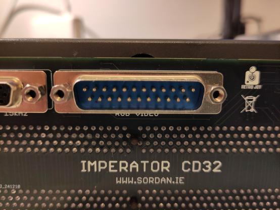 Closeup of the Imperator CD32, showing as the 23 Pin RGB port blocks the cover screw hole.