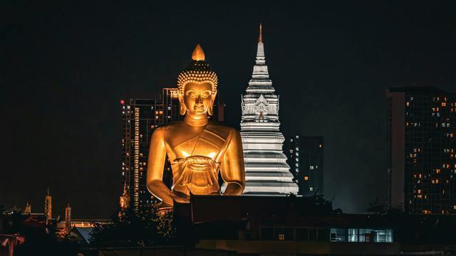 Giant gold Buddha statue at night in Bangkok.