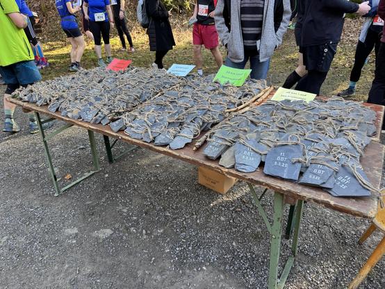 A desk full with hand made medals from slate, sorted by race in increasing size. 