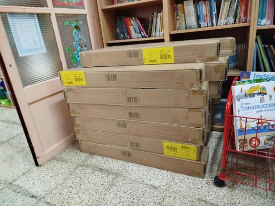 Capses de cartró horitzontals apilades a la biblioteca de l'escola.