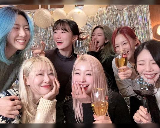 group shot of the 7 dreamcatcher members smiling, holding drinks. happy times.