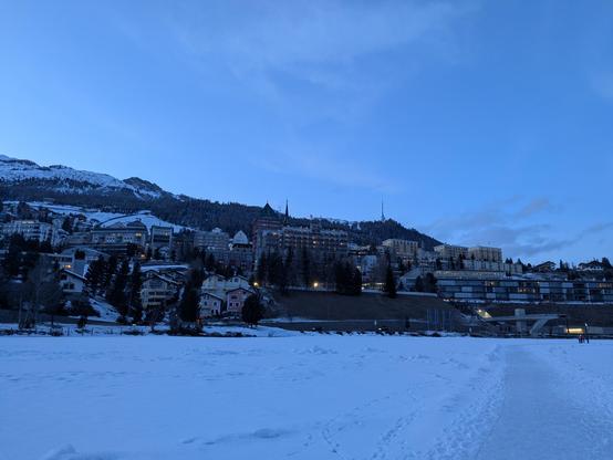 La nuit tombe sur St Moritz Dorf, ciel bleu foncé. Pris depuis le lac gelé.
