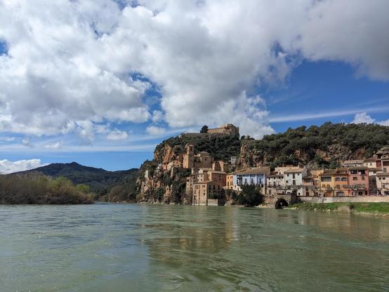 The beautiful town of Miravet, right next to the Ebre river, with a row of town houses near the shore and a Templar castle at the top of the hill