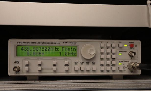 Frequency generator: a grey box with square buttons, a round dial, and a display showing the following values:
439.987500 Mhz, FMsin, 0.0 dBm, 1.0  kHz