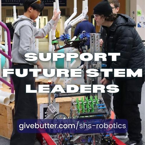 Students work on a robot on a practice field.