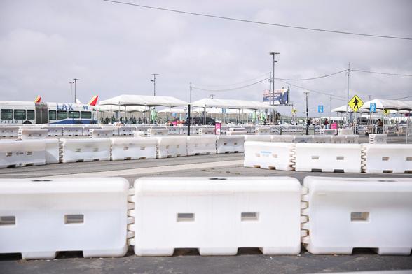 A series of white TrafFix Water-Wall barriers protecting the rideshare pickup and drop off location at the LAX airport.