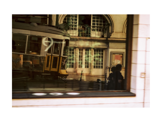 reflexions in a big shop window showing one of lisoba eletrico trams and buildings