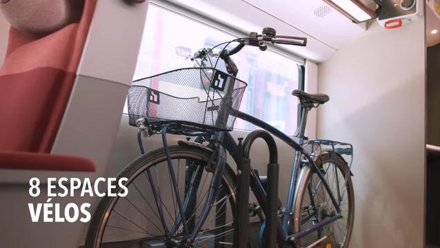 Video screenshot of a bicycle in upright position (both wheels on the ground) along a window behind a red seat. Source: https://youtube.com/watch?v=yjxaci5c5nE at 2 minutes.