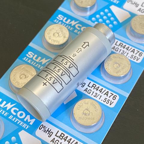 A PX21 battery adapter, with a blister of LR44 batteries under it.