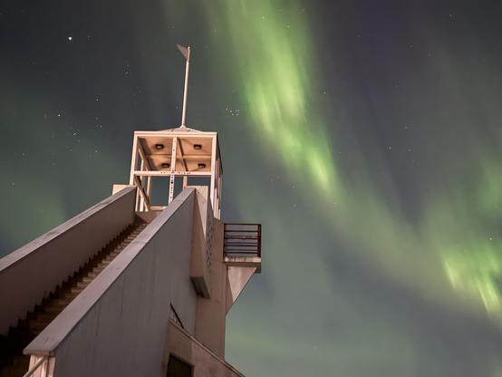 A lighthouse in Oulu with the aurora in the background 