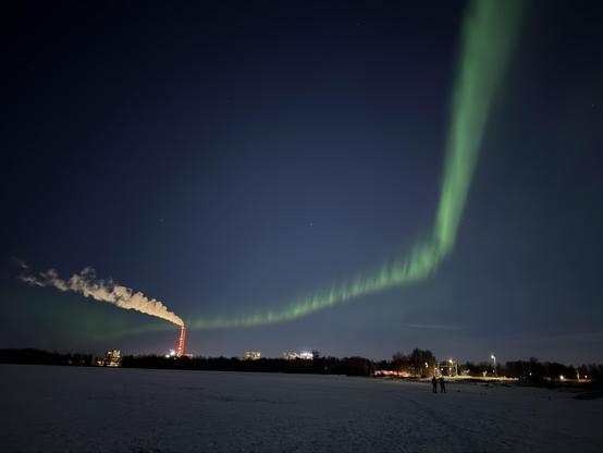 The aurora curving around to look like it’s coming out of a big smokestack 