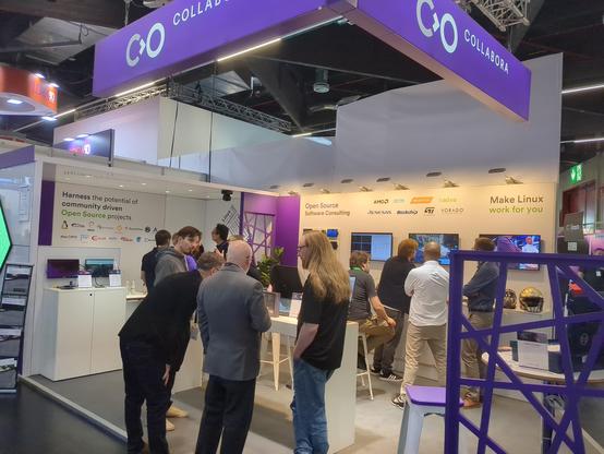 A picture of the Collabora booth, people standing around chatting.