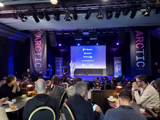 Conference in the RIO theatre with people seated watching a stage with opening speech being made