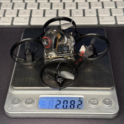 A tiny 65mm FPV drone (Tiny Whoop) on a scale showing 20.82 grams.