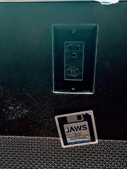wall under Marriott bar festooned with a JAWS 30th Anniversary sticker