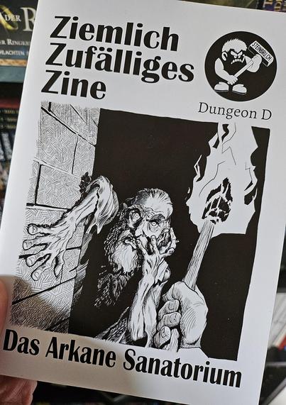 Foto vom Cover des Ziemlich zufalliges Zine. Es zeigt einen wirren bärtigen Mann im Schein einer Fackel.