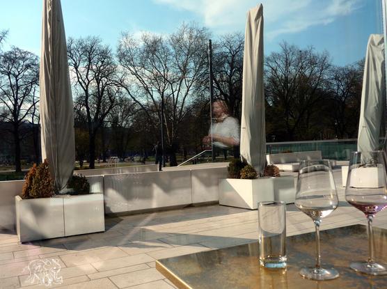 in front empty glasses, a  waiter in the mirror of the invisible window hoovering to a park