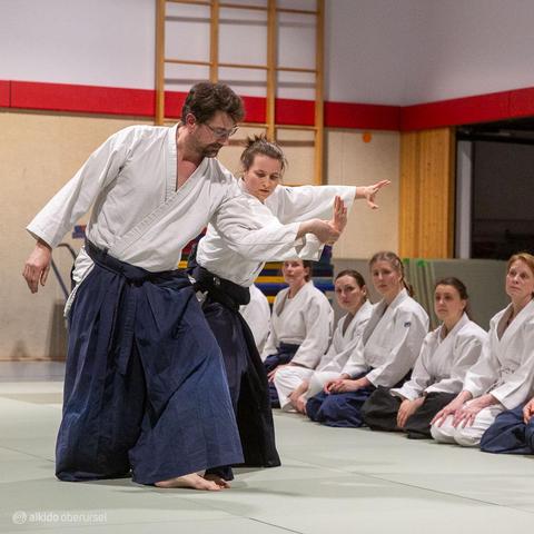 Female aikidoka showing a breath throw with male attacker
