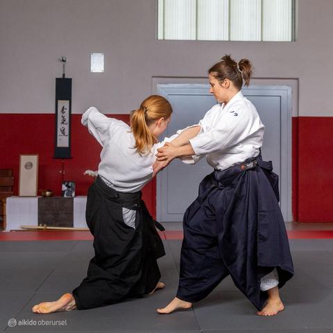 Female aikidoka showing a arm-pinning technique