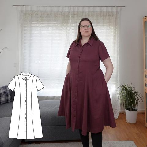 A woman in a red princessline dress with collar and short sleeves, hands in the pockets