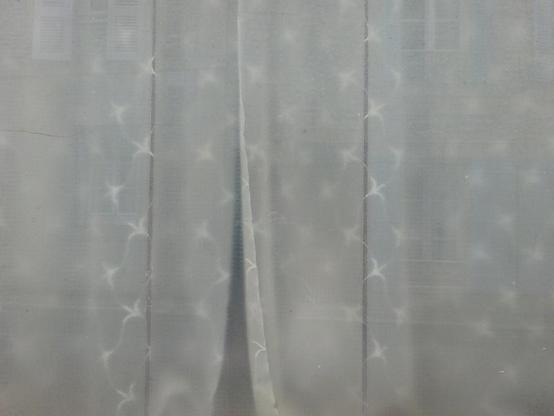 rideau blanc un peu transparent avec des petites broderies étoilées blanches