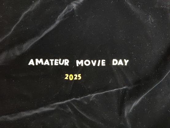 Schriftzug Amateur Movie Day 2025 auf schwarzem Hintergrund.