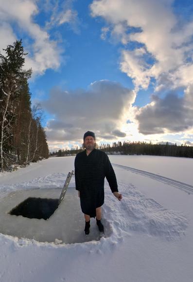 Mies avannon vierellä. Sininen taivas, jossa hieman pilviä. Aurinko pilkistää pilven välistä.