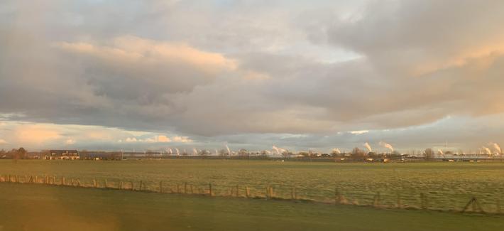 Een horizon met heel veel "rokende" schoorstenen bovenop kassen die niet zichtbaar zijn in de foto.