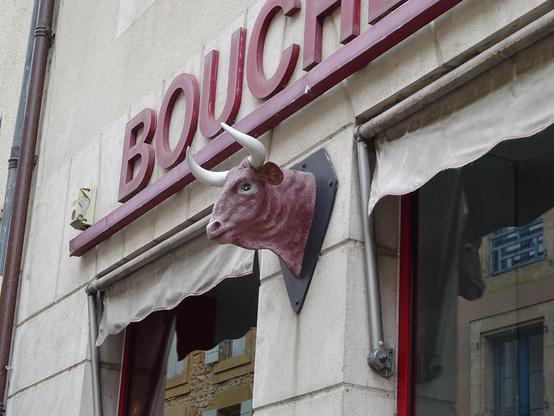 enseigne de boucherie avec une tête de vache à cornes en relief