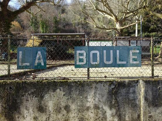 écriteau LA BOULE devant un terrain de pétanque