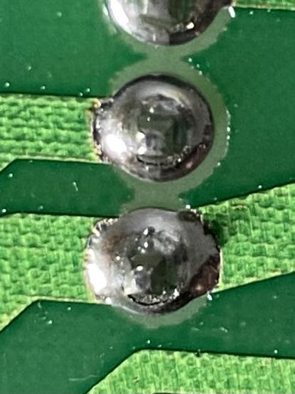 A close up of a solder joint with fractures on it.