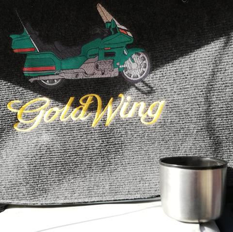 Stickerei Motorrad mit Schriftzug Goldwing, davor die Tasse einer Thermoskanne.