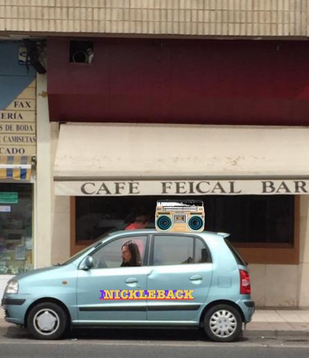 jonny sitting in a car with “nickleback” stencilled on the side and a beatbox strapped to the roof.  