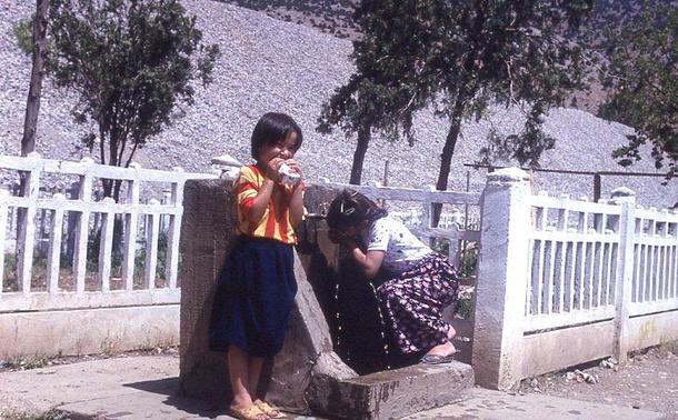 deux petites filles devant une fontaine, dans une gare