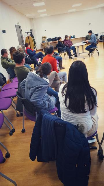 Salle de classe, le public attentif tourné vers les comédien-es jouant les scènes de notre théâtre forum À... Venir.