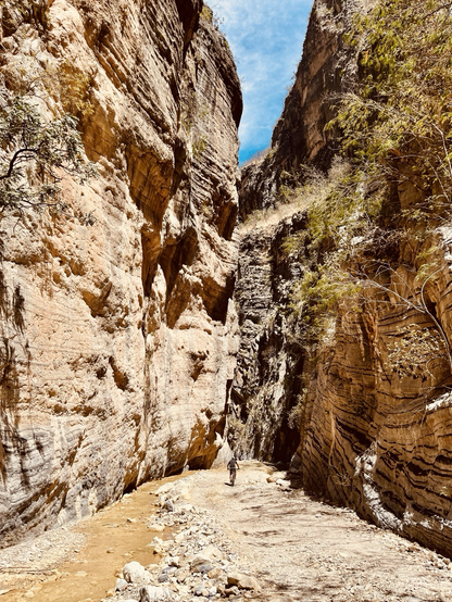 Una bicicleta pasando por en medio de las paredes de un caño 