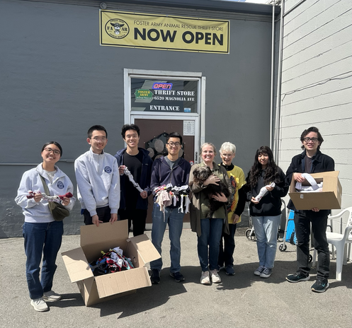 A group of young pet lovers and two FAAR volunteers holding donations