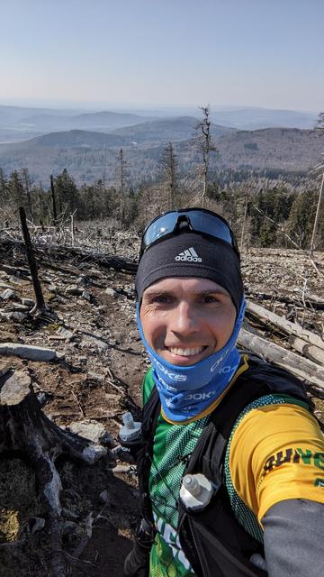Daniel beim Abstieg vom Altkönig in einer kargen, steinigen Landschaft, im Hintergrund sind Berge zu sehen