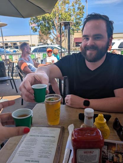 AJMaxwell drinking a shot of Jameson out of a tiny green shot glass in celebration of St. Patrick's day