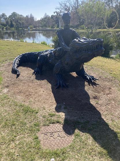 Big statue in a park, pond behind it