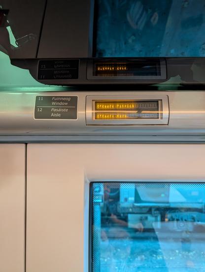 A digital sign above train seats reads: "O'Keefe, Patrick. O'Keefe, Kara."