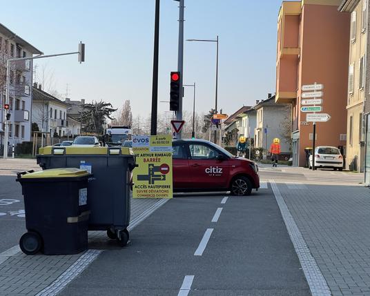 Une Citiz rouge stationnée à la perpendiculaire sur la piste cyclable, vue depuis la route d’Oberhausbergen