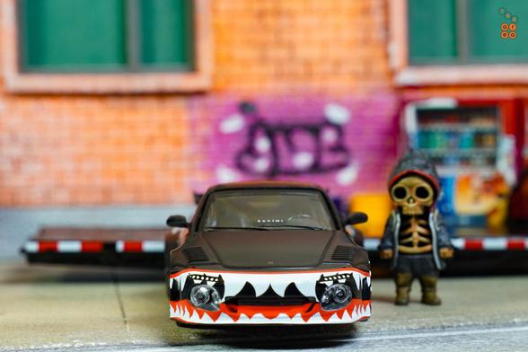 A front side of Old & New 997, Matte Black by Tarmac Works in 1:64 scale with 1:64 figure on AREA 164