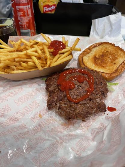 A well done hamburger and portion of skinny fries 