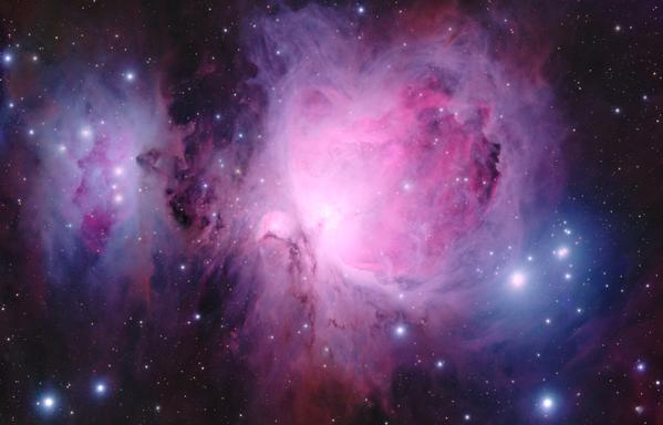 M42 The Orion Nebula and Running Man Nebula:
Background is black with some stars dotted throughout, including a few particularly bright stars surrounded by a blue hazy halo.

Filling most of the center and center-right areas of the image is a bright red-pink nebula which has a multi-layered look and different pink hues and also some purple hues on the outside edges. There are also streaks of dark brown squiggly lanes (dust) throughout.

At the center left of the image is a mostly blue nebula surrounding some red'ish nebula in the middle which could be considered in the simplistic shape of a cartoon "man".