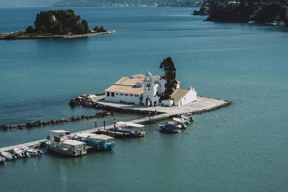 A quaint white church located on a small island, with the ocean stretching out around it