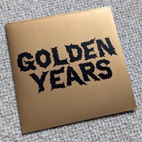 Ein goldfarbenes Albumcover mit den Worten "GOLDEN YEARS" in fettem schwarzem Schriftzug. Der Hintergrund ist glatt und glänzend.