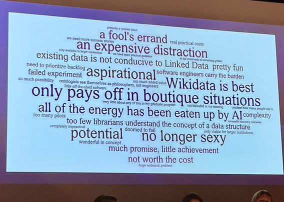 Photo of the single slide, separately. It shows a word cloud with statements about how conference attendees "really feel about linked data". Statements include "only pays off in boutique situations" - "Wikidata is best" - "existing data is not conductive to Linked Data" - "much promise, little achievement" ...
